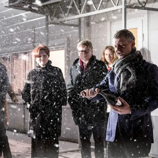 Люди на улице в снегопад, один мужчина открывает шампанское, вечер, зимняя атмосфера, светящиеся огни города