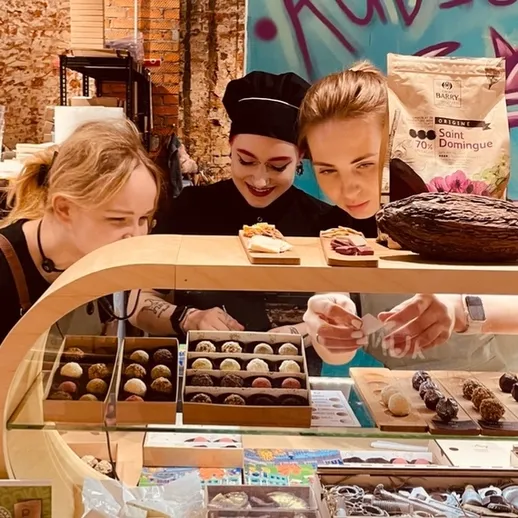 Девушки выбирают сладости в кондитерском магазине на рынке во время весеннего праздника