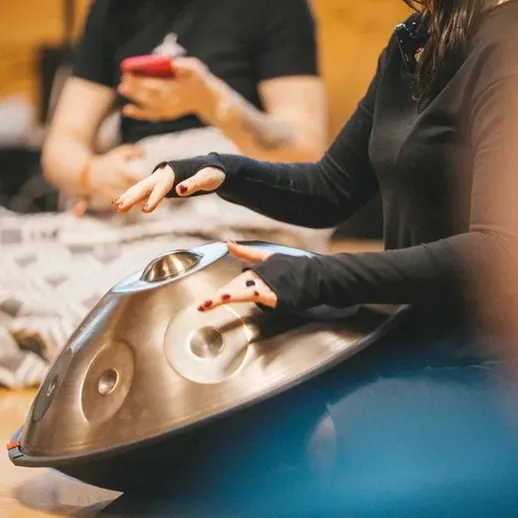 Игра на ханге в кругу друзей во время вечеринки в уютном помещении