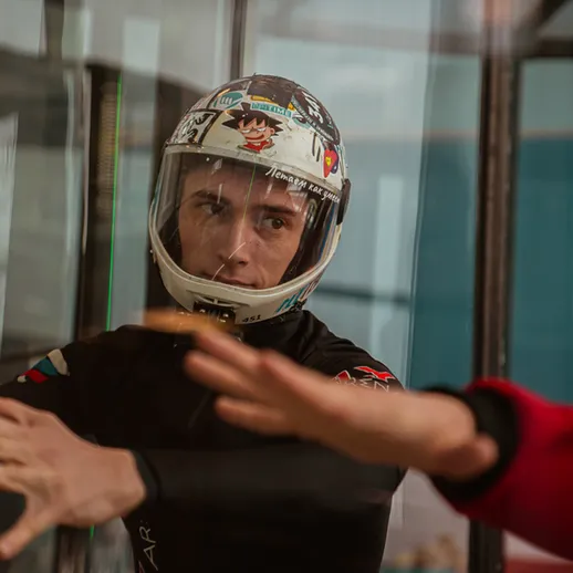 Участник в свободном падении во время тренировочной сессии на вертикальном ветровом туннеле