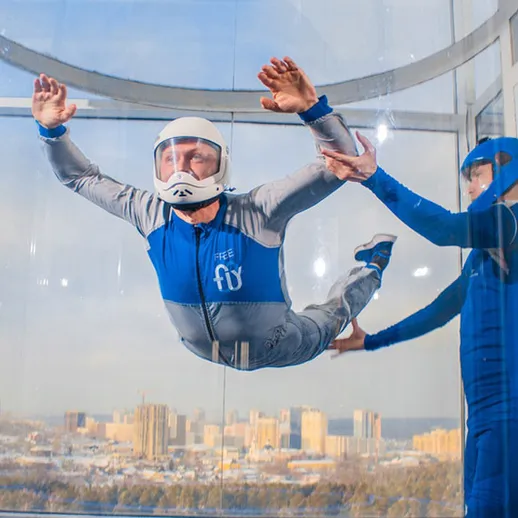 Люди в наклонной трубе для фристайла на высоте, занимающиеся свободным падением в центре города в ясный день