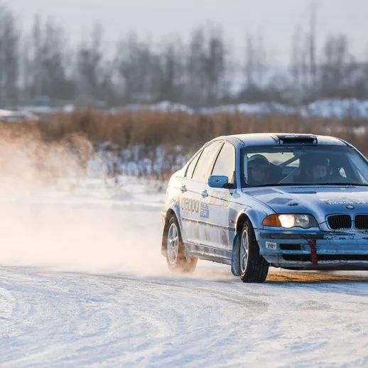 Зимние гонки на BMW на заснеженной дороге в России в солнечный день
