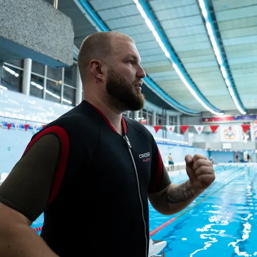 Тренировка пловца в спортивном бассейне во время турнира по плаванию в поздний вечер