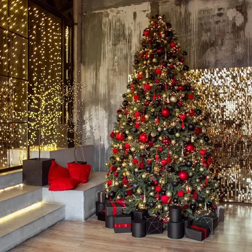 Ёлка украшена красными и золотыми шарами в стильном интерьере