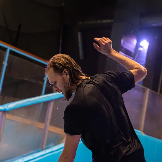 Молодой человек катается на сноуборде в крытом споте и наслаждается трюками в увлекательной обстановке