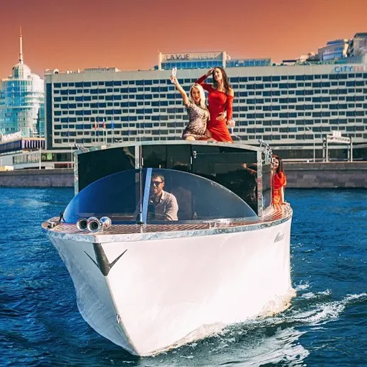 Люди на яхте наслаждаются прогулкой по реке в центре города под ярким закатом