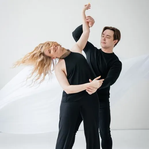 Энергичный танец пары в студии с белым фоном, выражающий эмоции и движение