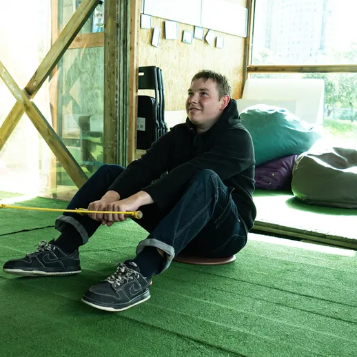 Мужчина катается на балансировочной платформе в спортивном центре в дневное время