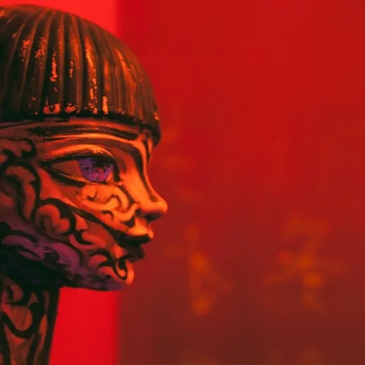 Изящная статуэтка в красном свете искусственного освещения в художественной галерее