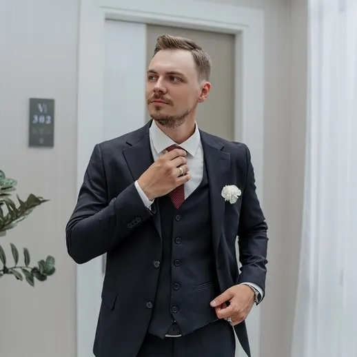 Стильный молодого человека в смокинге готовится к важному событию в современном помещении