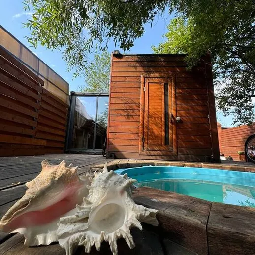 Уютная уголок у бассейна и раковины на деревянной палубе под ясным небом