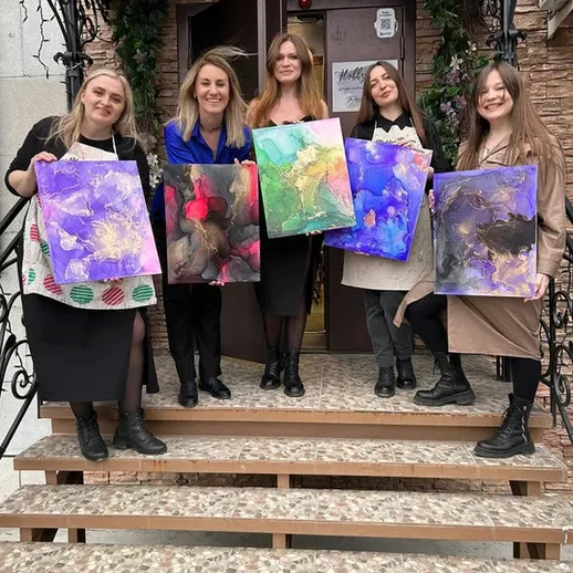 Группа женщин с холстами на ступенях художественной студии в зимний день