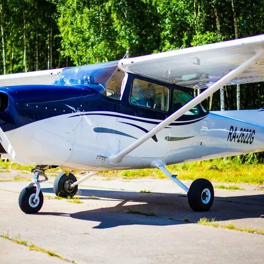Летний день на аэродроме: маленький самолет на парковке среди зелени, готовый к взлёту