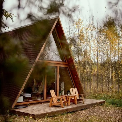 Уютный загородный дом на фоне осеннего леса с террасой и комфортной мебелью