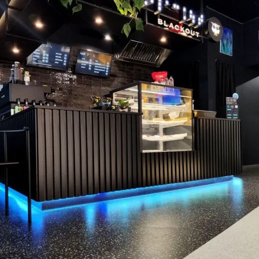 Современное кафе с минималистичным дизайном и подсветкой в тёмных тонах, где подают различные блюда и напитки