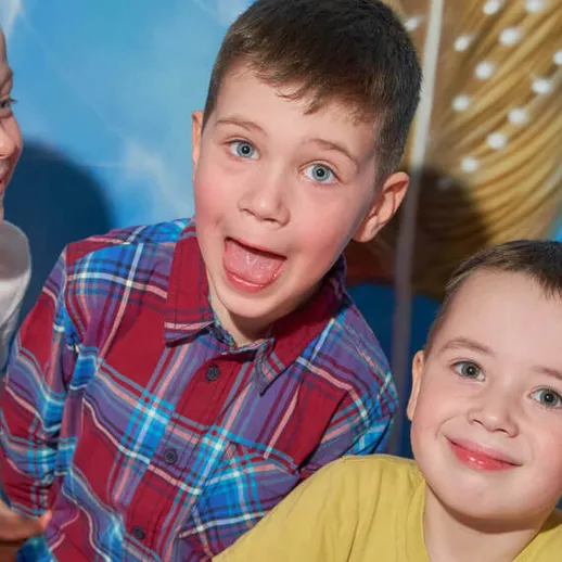 Друзья радостно проводят время на детском празднике, улыбаясь и смеясь