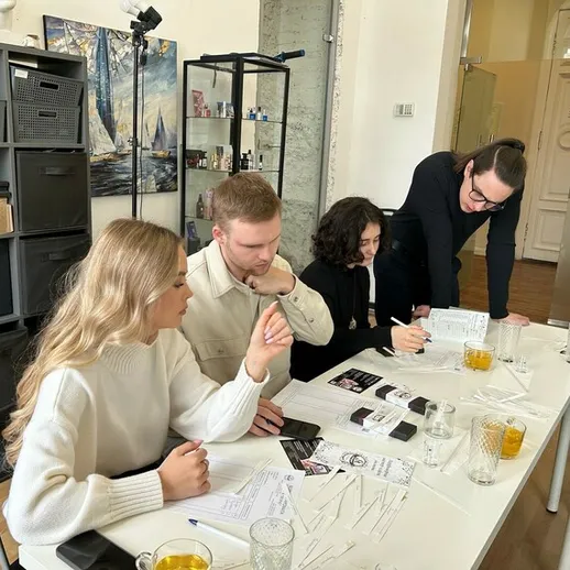 Группа людей обсуждает проект в светлом офисе во время деловой встречи с напитками на столе