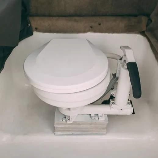 Установленный туалет в небольшой лодке на реке в светлое время суток