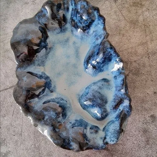 Стильная керамическая посуда с уникальным черно-синим узором, выполненная вручную, на фоне светлого стола