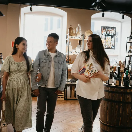 Три человека наслаждаются временем в магазине продуктов и напитков, расположенном в уютном городе