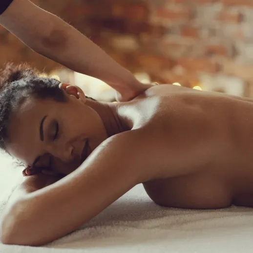 Расслабляющий массаж женщины в спа-салоне с мягким освещением и уютной атмосферой