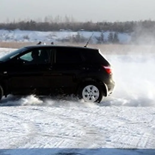 Автомобиль на снегу демонстрирует дрифтинг на зимнем соревновании в открытом пространстве