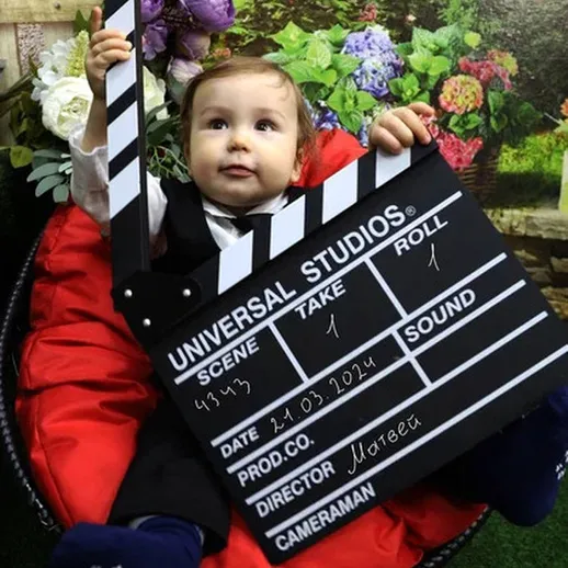 Младенец с кинощёткой в тематической комнате, увлеченно готовится к съёмкам в 2024 году