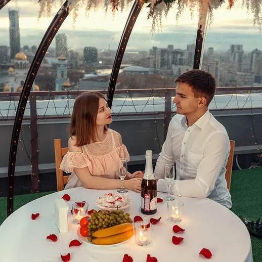 Романтический ужин на крыше с видом на город в вечернее время