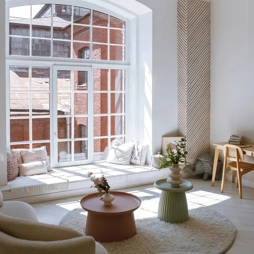 Стильный интерьер светлой комнаты с уютной зоной для отдыха и рабочим столом