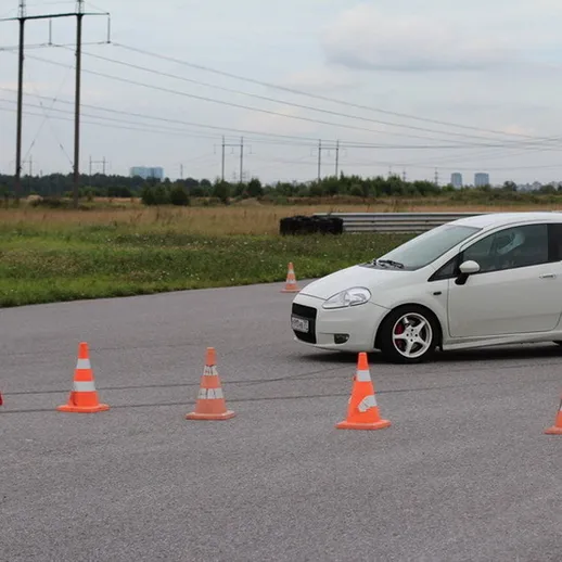 Управление автомобилем на учебной площадке с конусами в безопасной зоне
