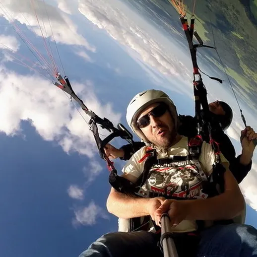 Парапланеристы наслаждаются полетом над живописным ландшафтом в ясный день