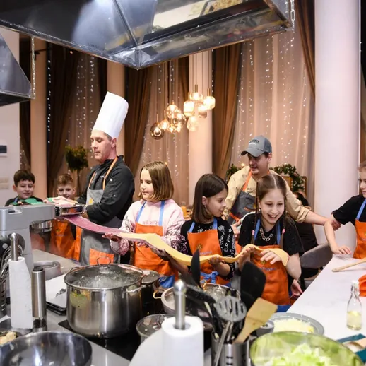 В детской кулинарной школе повар обучает детей готовить пасту в уютной обстановке