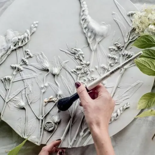 Создание рельефной картины с цветами на круглом холсте в мастерской в осенний день