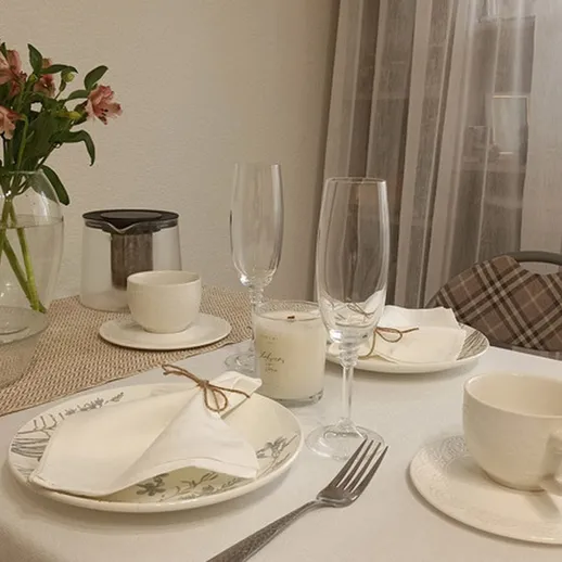 Столовая сервировка для романтического ужина с цветами в вазе и приятной атмосферой