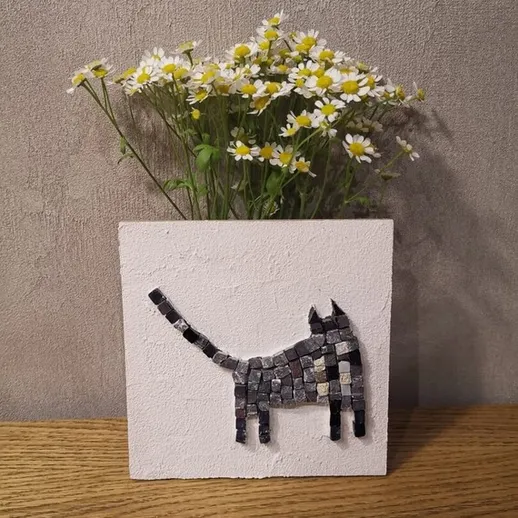 Декоративный элемент с изображением кошки и цветами на деревянном столе