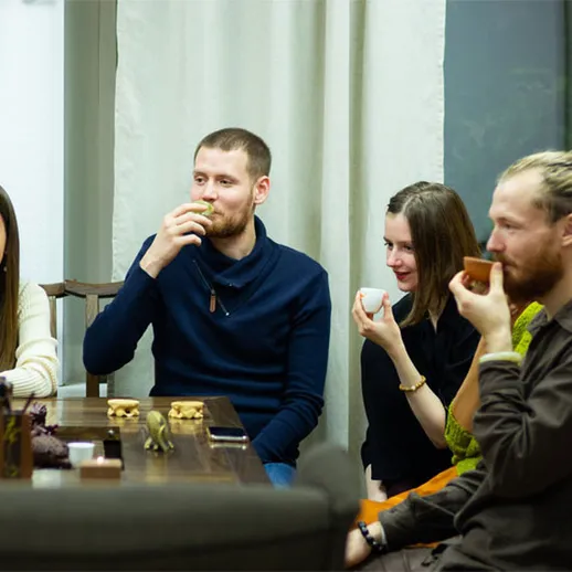 Друзья наслаждаются чаепитием в уютном кафе с настольными играми в вечернее время