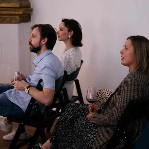 Группа людей наслаждается мероприятием с бокалами вина в уютном помещении