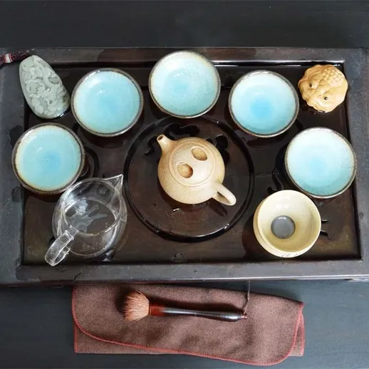 Чайная церемония с керамическим чайником и чашками на черном столе