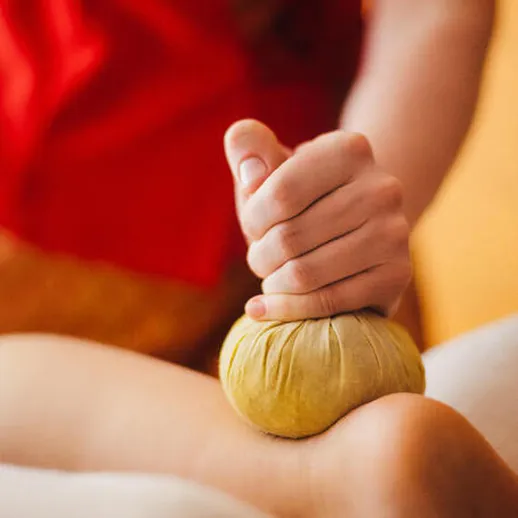 Процедура массажа с использованием травяного мешочка в спа-салоне
