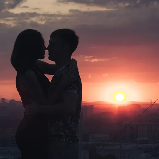 Романтический момент Sunset на крыше с влюбленной парой в вечернем свете