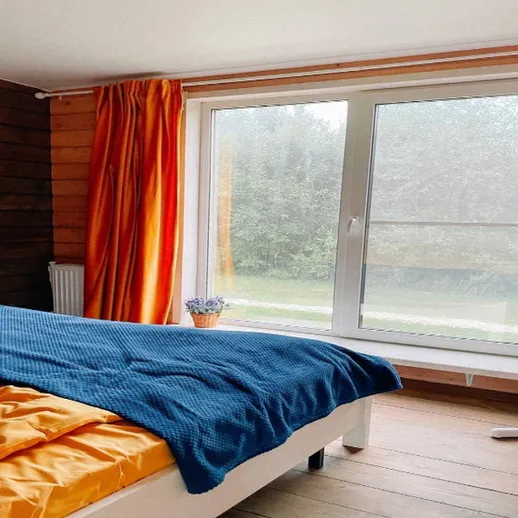 Уютная спальня с видом на природу и солнечными шторами в загородном доме