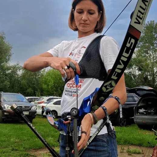 Женщина готовится к стрельбе из лука на соревнованиях в России под облачным небом