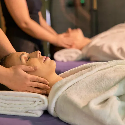 Массаж лица и шеи в спа-салоне, женщины получают расслабляющую процедуру в вечернее время