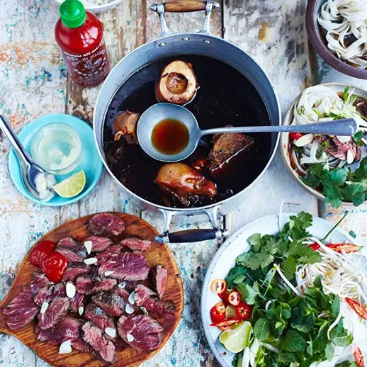 Вкусный ужин с мясом и овощами на столе с разнообразными блюдами в уютной обстановке