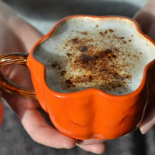 Кружка с горячим напитком на руке человека с корицей, уютное утро в осеннем об interiores