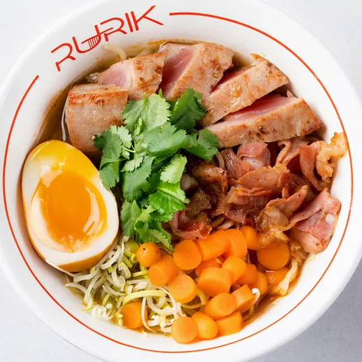 Чаша с лапшой, свининой, яйцом и овошами в ресторане на обед или ужин