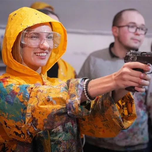 Женщина в желтом комбинезоне стреляет из пистолета во время тренировки на стрельбище в городе