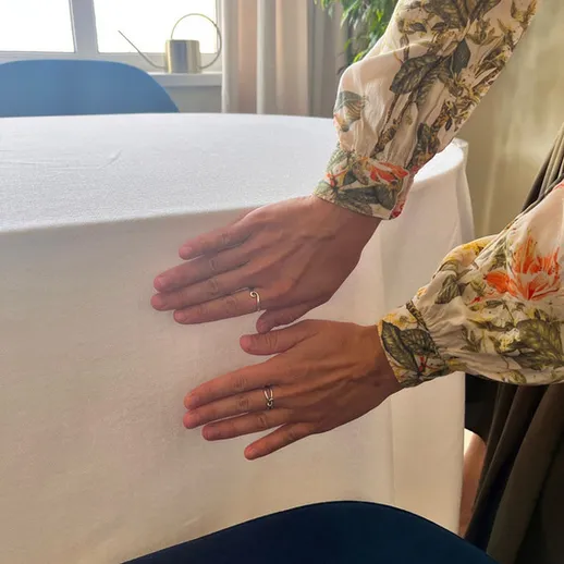 Установление белой скатерти на столе в современном интерьере с яркими элементами