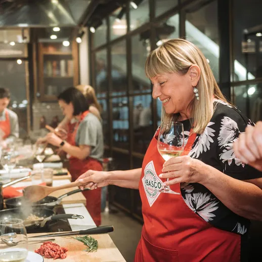 Участники кулинарного мастер-класса готовят блюда в уютной атмосфере, наслаждаясь процессом и общением в вечернее время