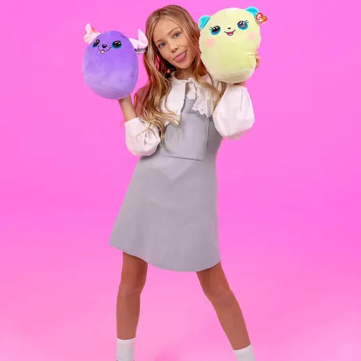 Девочка с мягкими игрушками на ярком фоне во время фотосессии